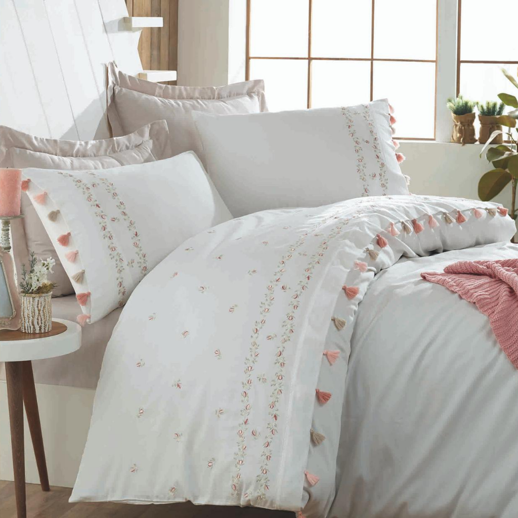 Fresh bedroom with white bedding set, having colorful tassels and floral designs