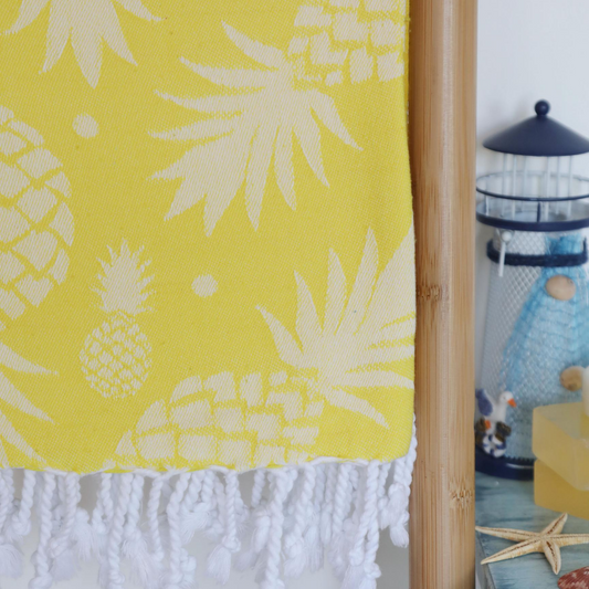 Yellow, pineapple Turkish towel has tassels at the borders