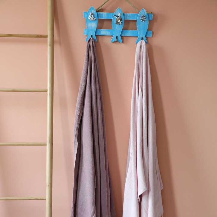 Powder-pink and dusty-rose color two Turkish peshtemal beach towels hanging on a wall